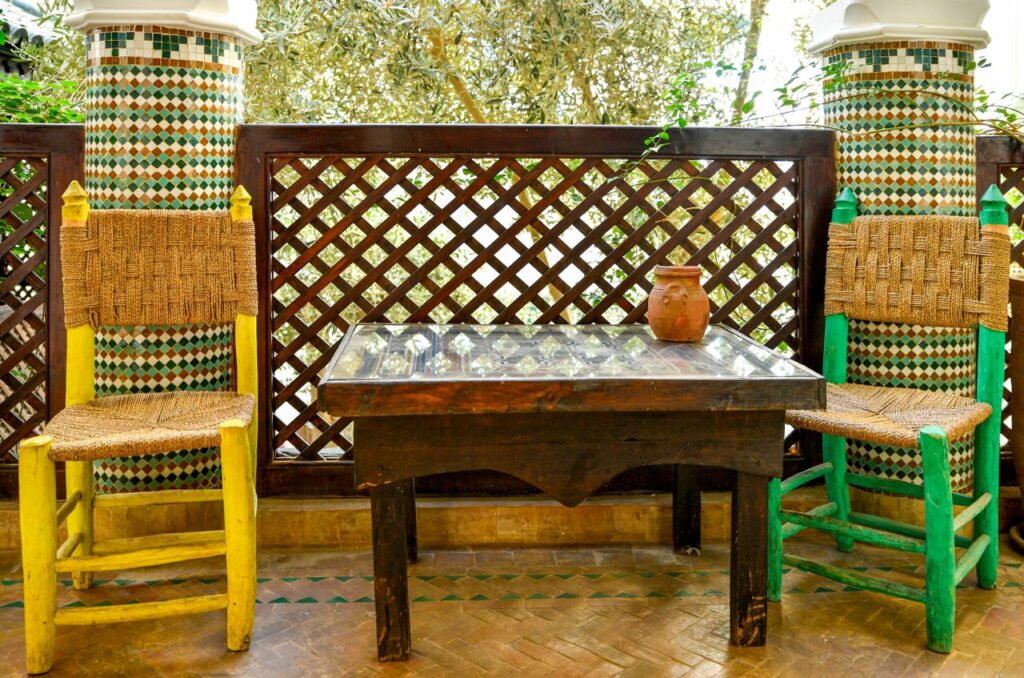 services-img Colorful courtyard with woven chairs and mosaic tiles in Marrakesh, Morocco.